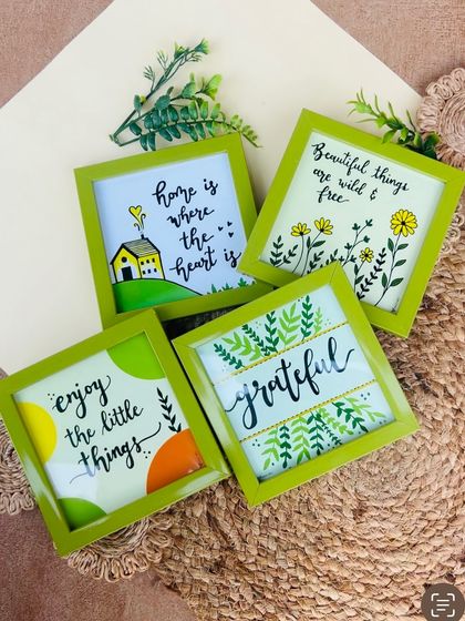Our 'Green Quoted Combo' is perfect for adding a touch of nature and positivity to your home. This image shows the four green glass frames included in the set, each with a unique hand-doodled design.