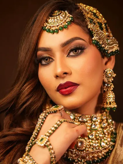 A striking pose that highlights the intricate hand jewelry (haath phool) and the flawless makeup.