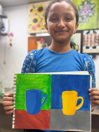 This student's wonderful smile says it all. She is happy with her artwork where she explored different color combinations for the same object study.
