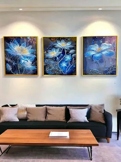 This set of three crystal paintings features luminous blue flowers against a dark, starry background. Hung together, they create a cohesive and breathtaking display of botanical beauty over a sofa or bed.