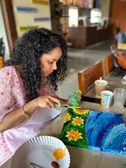Lost in the world of color and texture. A participant uses a palette knife to create beautiful sunflowers during our knife and finger painting workshop.