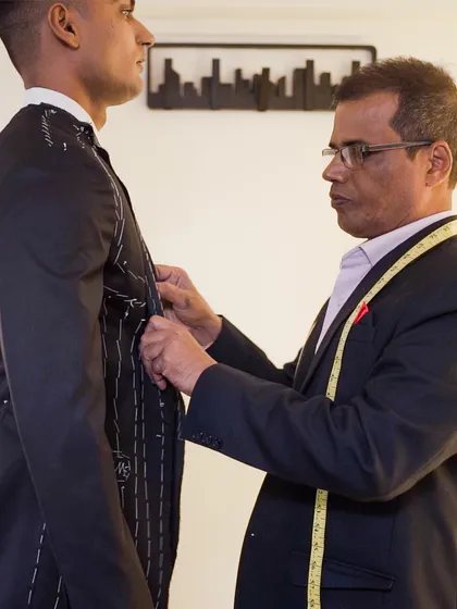 A cloth fitting is more accurate than a measuring tape alone. During the first "baste" fitting, we check the fall and drape of the loosely stitched garment on your body to ensure a perfect balance.