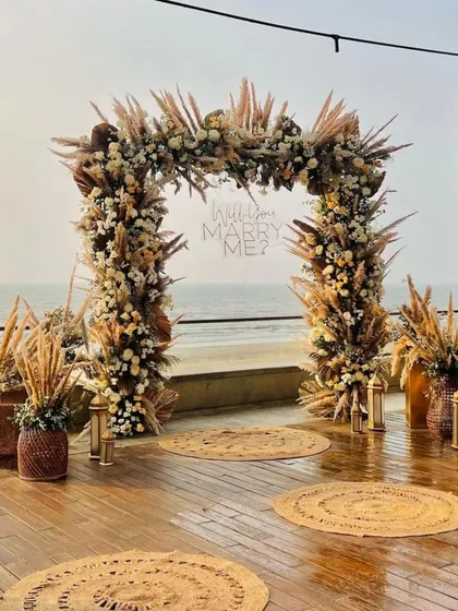 Another perspective of the proposal setup, showing the arrangement of jute rugs and lanterns leading to the main arch. Every detail is planned to build up the perfect moment.
