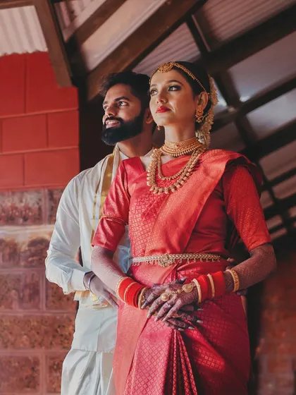 A stylish portrait of the couple in their traditional South Indian wedding attire, captured with a modern, editorial feel.