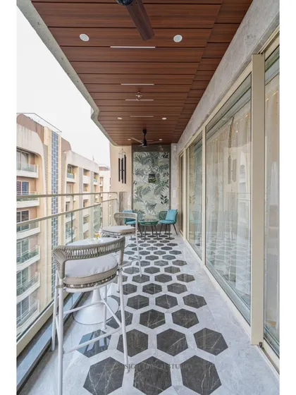 This balcony is designed to feel like a cozy outdoor room. It features a stylish bar-height seating arrangement, a beautiful hexagonal-patterned marble floor, and a warm wooden-paneled ceiling.