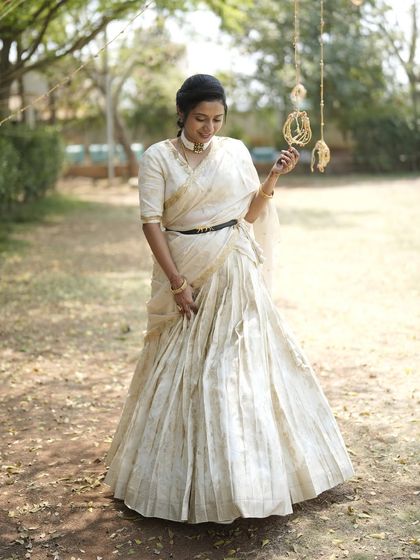 My dear friend Nithya shines in this custom-made light gold lehenga. I designed it with a modern, draped dupatta that can be belted at the waist, creating a look of effortless elegance for her special event.