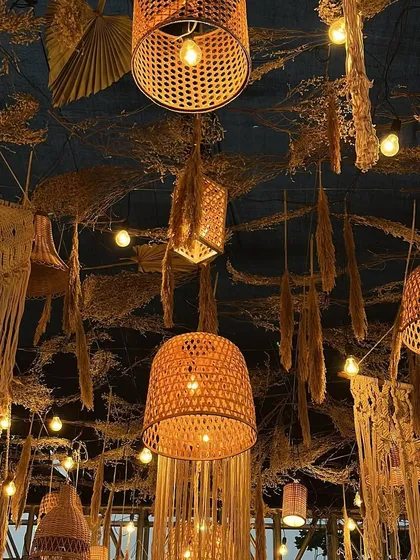 The lighting design is key to a rustic theme. Here, you can see how we mixed different styles of woven and bamboo pendant lights to cast a warm, inviting glow over the entire reception space, creating a truly magical ambiance.