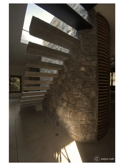 I believe staircases should be sculptural centerpieces. In this apartment for filmmakers, cantilevered concrete steps emerge from a random rubble stone wall, creating a dramatic ascent towards a skylight that bathes the space in natural light.