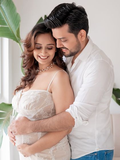 An intimate couple's portrait from a bright, airy studio maternity session.