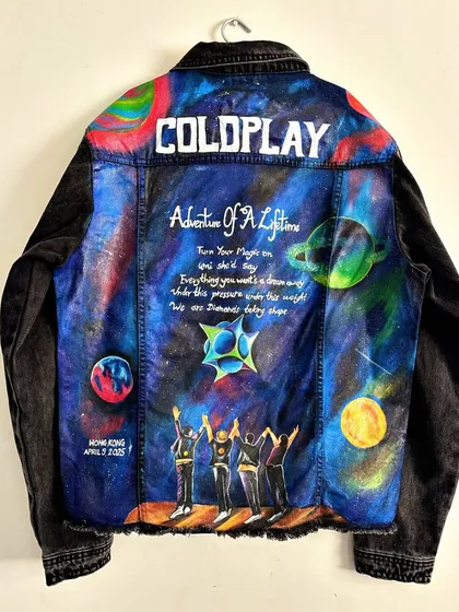 Another take on a Coldplay-themed jacket, this time on black denim. This piece features a different cosmic design inspired by their "Adventure of a Lifetime" theme, complete with planets, stars, and hand-lettered lyrics, created for a fan's concert experience in Hong Kong.
