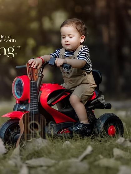 The wonder of childhood is a treasure worth capturing. A toddler with a guitar on his lap rides his toy motorcycle.