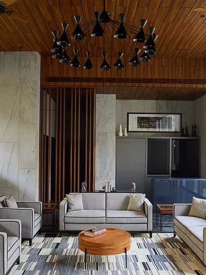 A full view of the garden lounge seating area, which includes a small pantry-bar and looks out onto the private pool area through large glass doors.