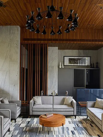 A full view of the garden lounge seating area, which includes a small pantry-bar and looks out onto the private pool area through large glass doors.