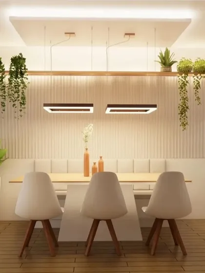 A front view of the dining table with bench seating. The linear pendant light and overhead planters create a striking visual element in the room.