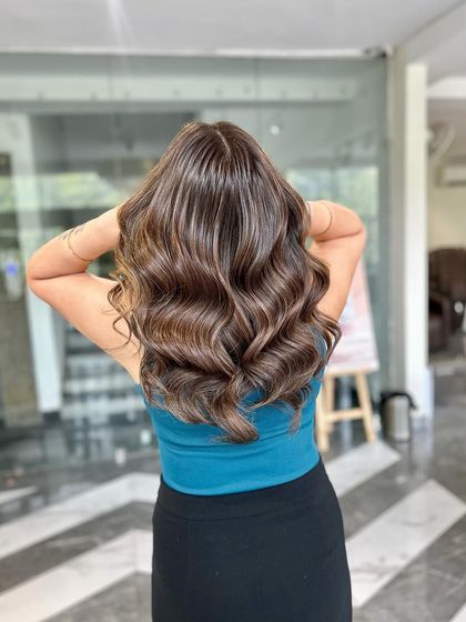 A gorgeous example of a soft brown balayage, styled with loose curls to showcase the dimension.