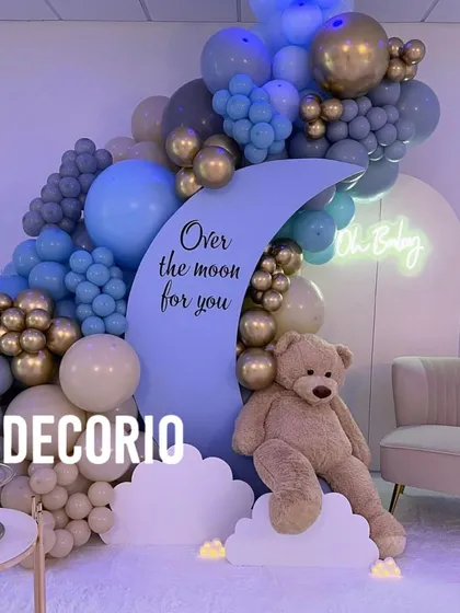 I love mixing themes to create something unique, like this "Over the moon for you" baby shower decor. It combines the dreamy moon element with a cuddly teddy bear and a sophisticated blue, grey, and gold balloon arrangement.