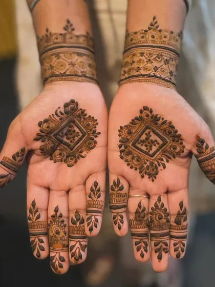 A simple yet elegant design featuring a diamond-shaped geometric motif in the center of each palm. The matching wristbands and finger details create a very cohesive and symmetrical look.