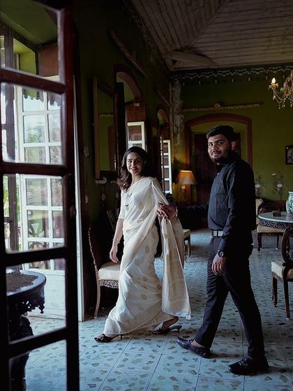 A candid moment of the couple walking through a heritage property, framed by a doorway. This shot feels like a glimpse into a private, happy moment.