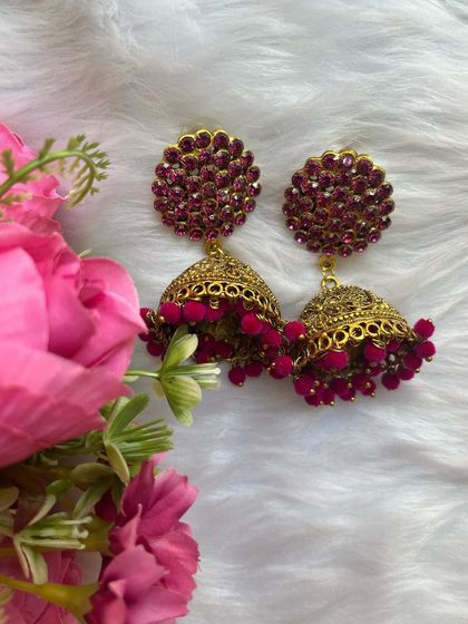 Various shots of the large pink stone stud jhumkas, showcasing their sparkle and rich color against different backdrops.