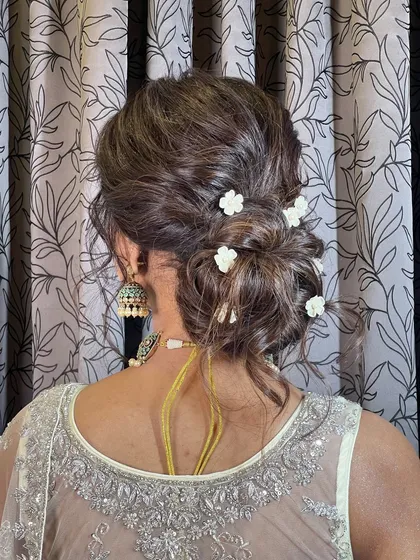 A close-up of the messy floral bun, showing the beautiful texture and placement of the flowers.