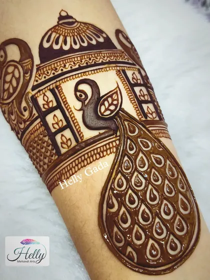 A bridal start-up design for the arm, featuring a large, detailed peacock. This is often the beginning of a full bridal sleeve.