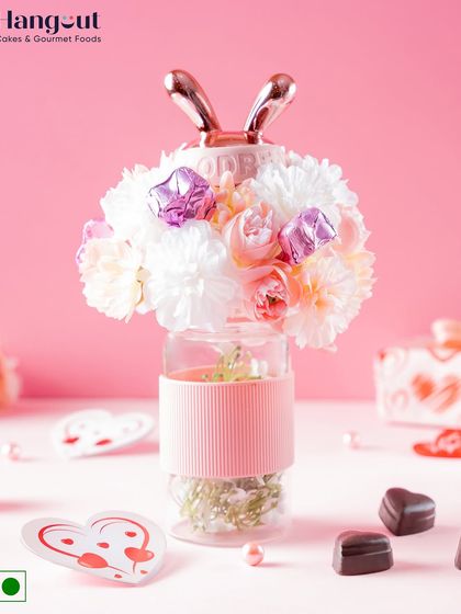 This cute Valentine's hamper features a bunny-eared sipper filled with chocolates and topped with a floral arrangement. It's a playful and charming gift for someone special.