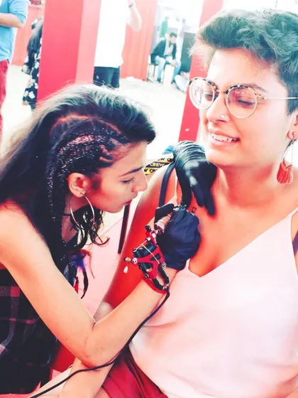 My artist Disha working on a client's tattoo at an outdoor event. We bring our art everywhere.