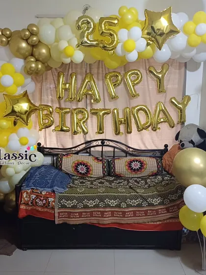 A cheerful yellow and white balloon arch for a 25th birthday celebration at home. We set this up around a bed, using foil letters and numbers, and daisy-shaped balloon accents for a fun look.