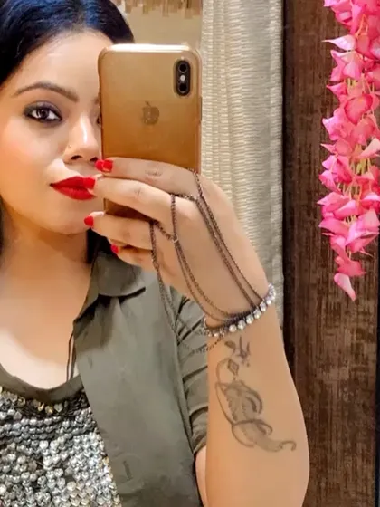 A selfie showcasing a hand chain bracelet and a tattoo, adding an edgy and personal touch to the outfit.