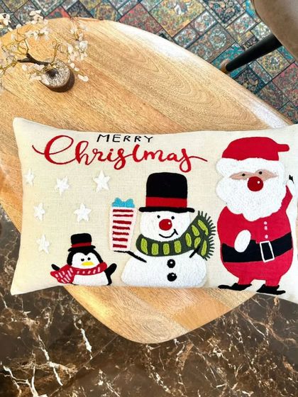 New arrival alert. This festive Christmas cushion cover features a cheerful Santa, snowman, and penguin, sure to bring the holiday spirit to your living room.