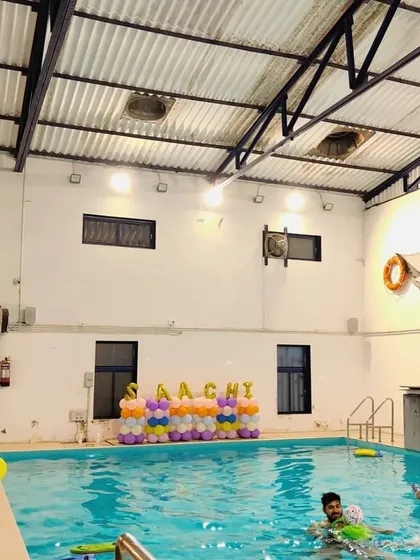 A poolside view of the birthday decorations, with custom balloon arrangements spelling out the birthday girl's name.