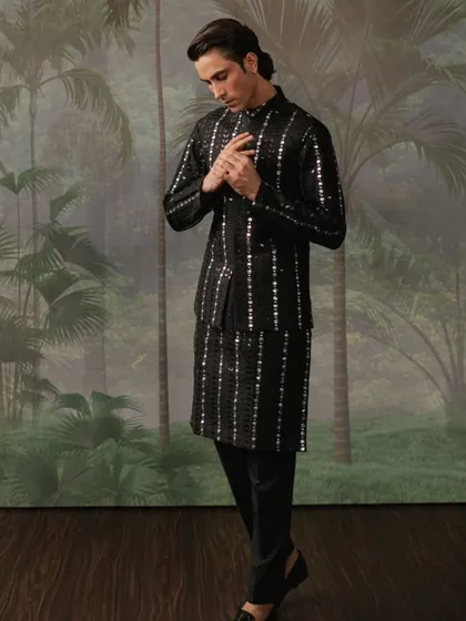 A black waistcoat set with vertical stripes of mirror work, creating a sleek and contemporary look.