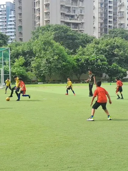 A wide shot of the boys' football match, capturing the energy and movement of the players across the field. Our tournaments are a great platform for students to apply the skills they've learned.