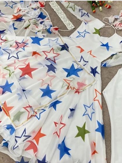 A fun, star-printed white suit set, laid out and ready to be stitched. We can work with any fabric to create your desired outfit.