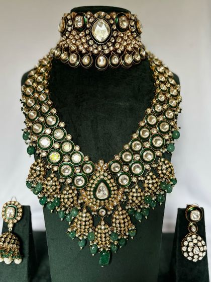 A grand bridal set with a choker and a long, cascading necklace. The green beads and Kundan work make this a standout rental piece.