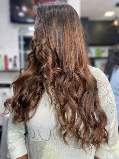 A beautiful example of long hair with caramel highlights styled into soft, romantic curls.