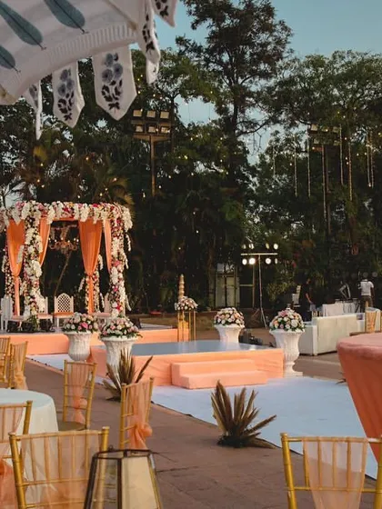 An elegant outdoor wedding setup. I designed this mandap with peach-colored drapes and florals, creating a soft and romantic atmosphere for a daytime ceremony.