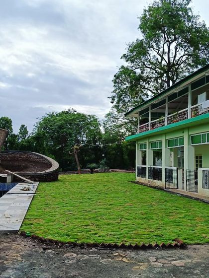 The newly laid lawn extends right up to the building and a curved seating area, integrating the landscape with the architecture.