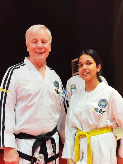A yellow belt student stands proudly next to the ITF President during his seminar in New Delhi.