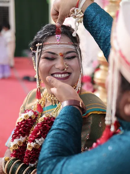 A beautiful moment as the groom applies sindoor. The bride's makeup is designed to be long-lasting and withstand all the emotional moments of the day.