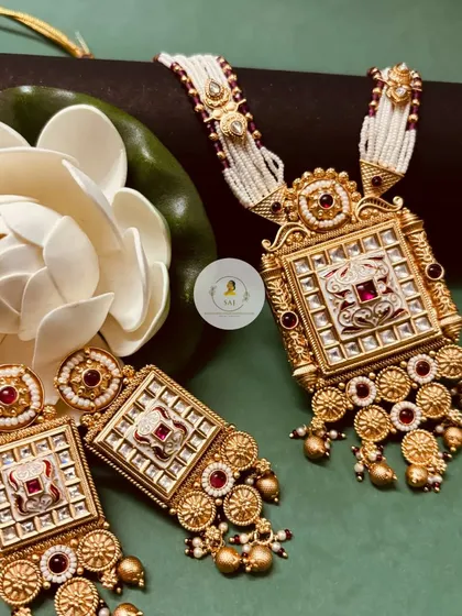 A beautiful Rajwadi Mala set, featuring a square pendant with intricate Meenakari work and pearl strings. This heritage piece is perfect for adding a touch of royal history to your look.