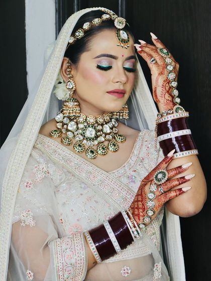 The bride showcasing her beautiful mehndi-adorned hands and nail extensions.