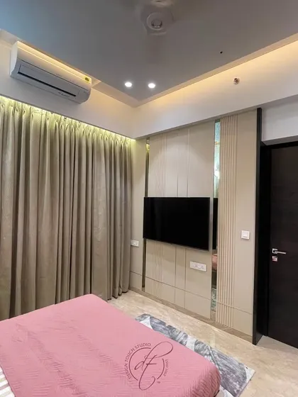 A view of the TV wall opposite the bed, featuring clean lines and integrated storage. The minimalist design ensures the focus remains on the room's serene and restful ambiance.