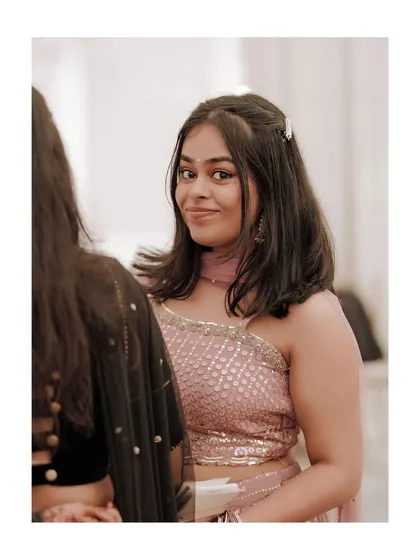 A candid shot of a guest at the reception, her smile capturing the happy atmosphere of the event.