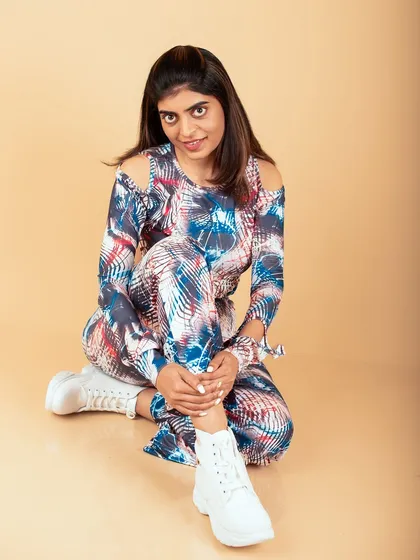A modern studio portrait with a fun, patterned outfit and white boots. This look is perfect for a fashion blog or social media content.