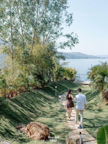 Walking together towards a shared future. This wide shot from a pre-wedding session captures the couple against a beautiful lakeside landscape, symbolizing their journey ahead.