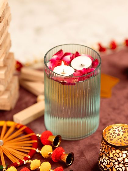Floating tea lights in a glass vase with rose petals. This is a classic, elegant decor shot that evokes a sense of peace and celebration.