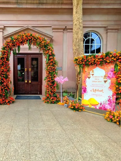 The entrance to this Turkish-themed Haldi ceremony featured a vibrant floral arch in shades of orange and red, perfectly framing the doorway and setting a festive mood.