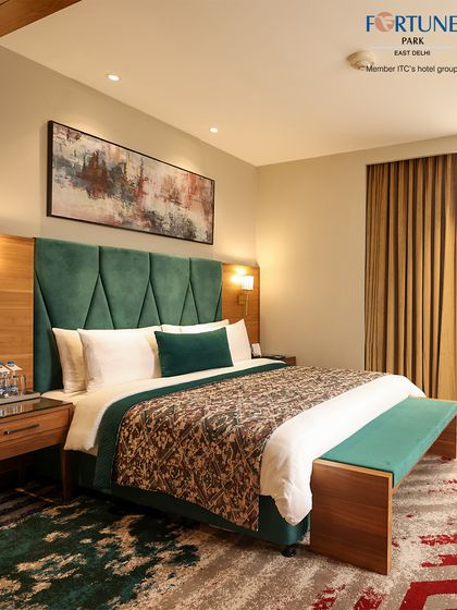 Another angle of our deluxe room, highlighting the rich textures and colours of the bedding and carpet. The abstract art adds a modern touch to the space.