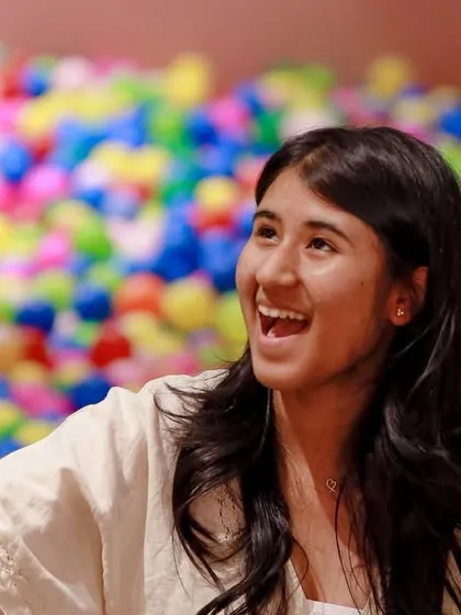 An adult guest enjoying the fun and watching the kids play in the ball pit during a party.